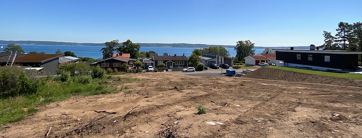 Vy från tomten: Vättern breder ut sig bortom villataken i Trånghalla